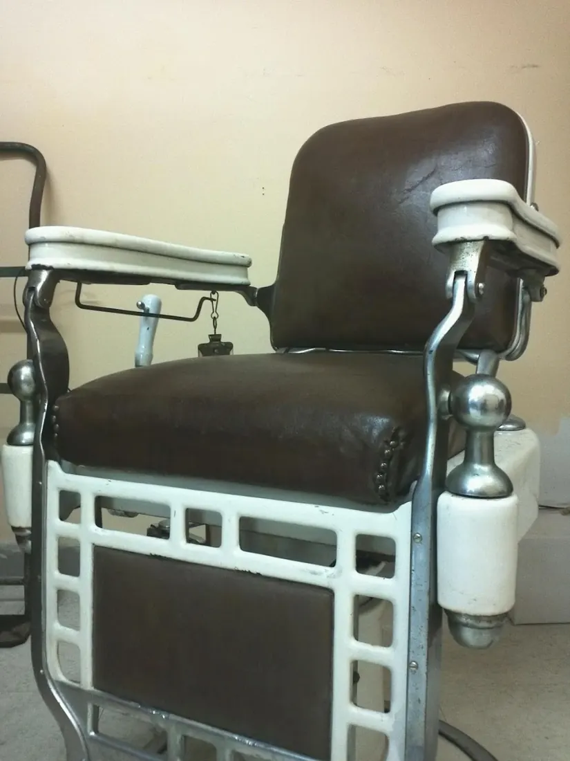 Vintage brown leather barber chair with white enamel base and chrome footrest